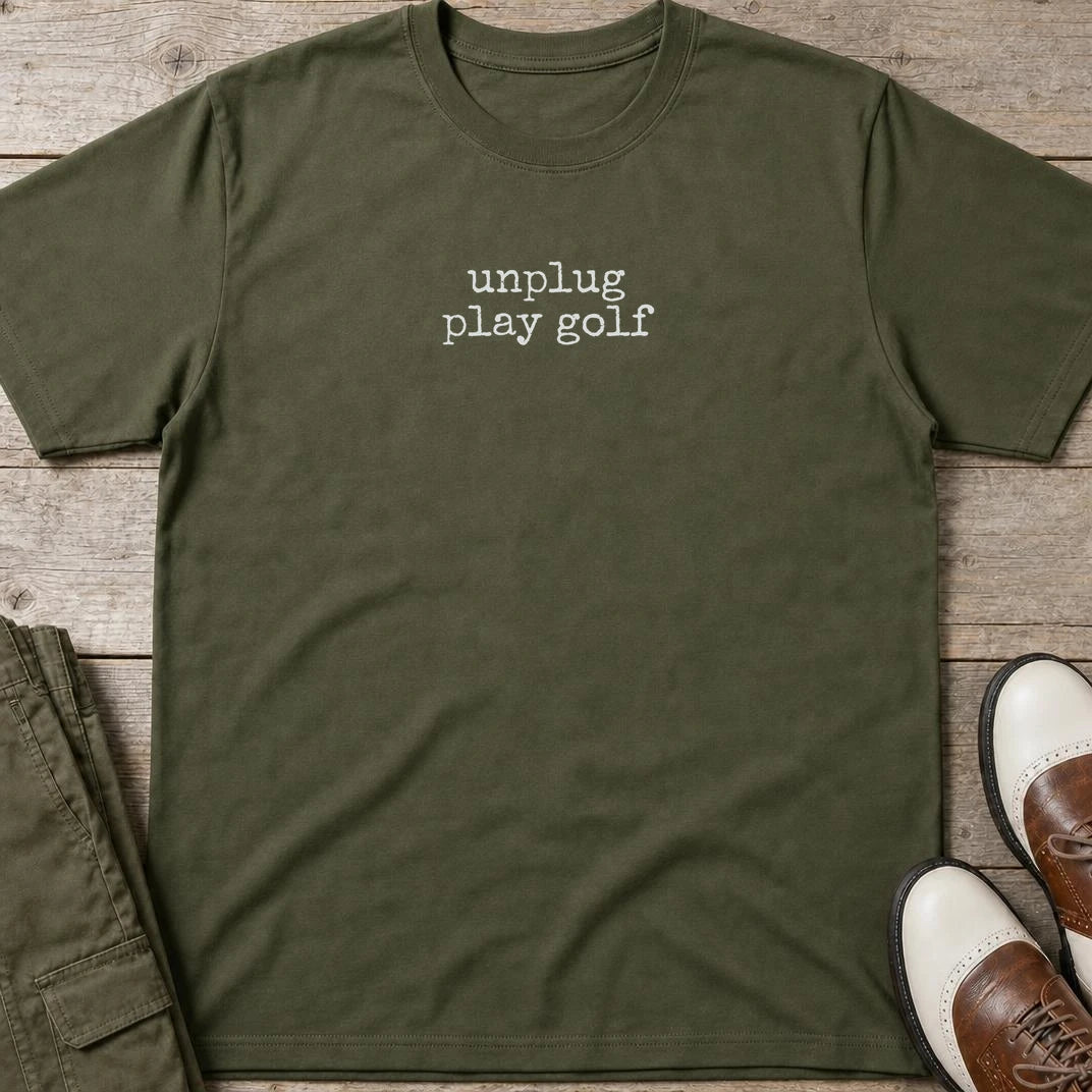 Unplug T-Shirt in Military Green lying on a plain floor. T-shirt is a unisex cut and 100 per cent cotton.