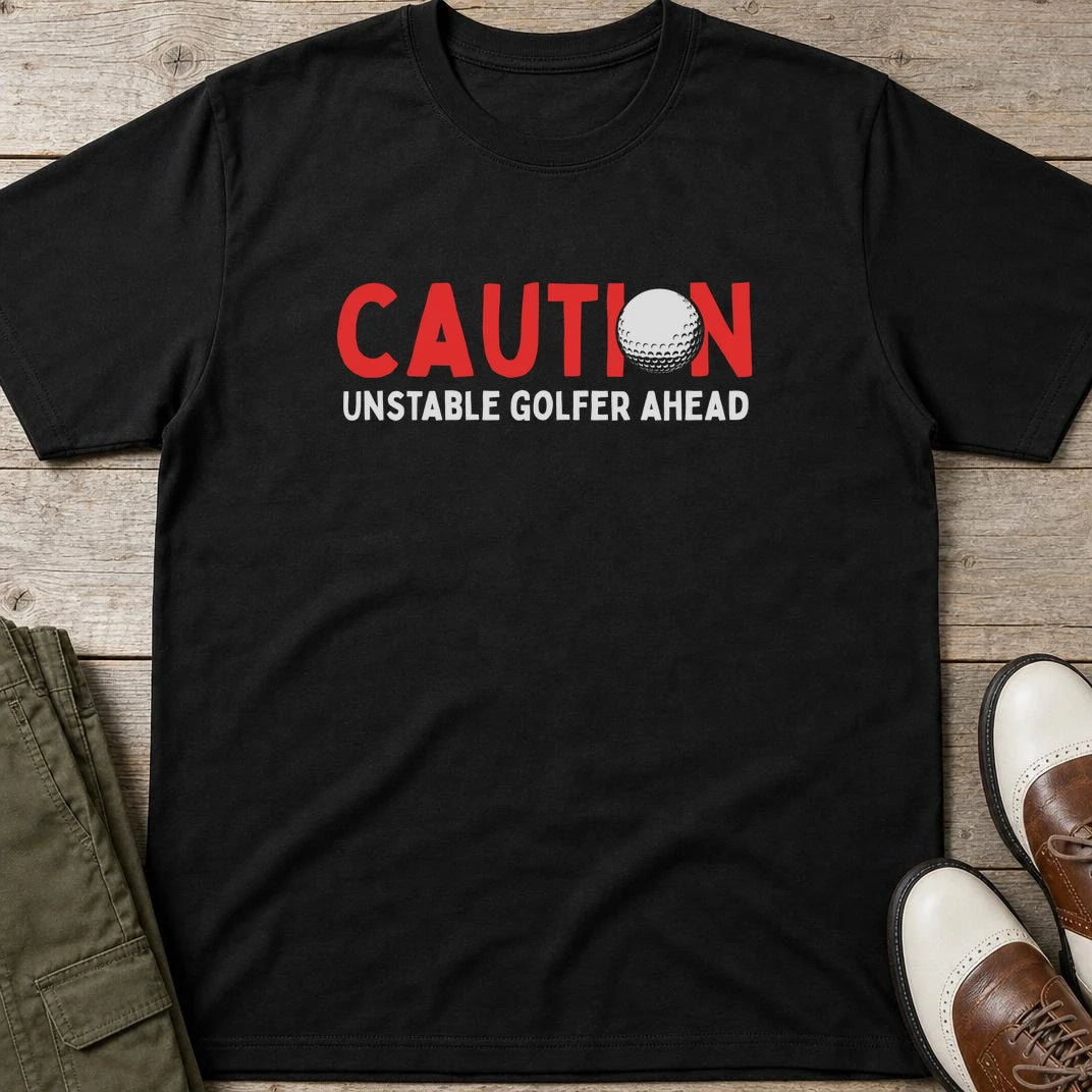Unstable Golfer T-Shirt in Black lying on a plain floor. T-shirt is a unisex cut and 100 per cent cotton.
