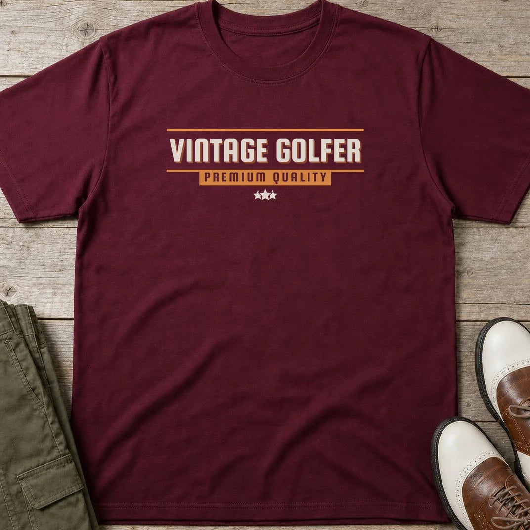 Vintage Golfer Quality T-Shirt in Maroon lying on a plain floor. T-shirt is a unisex cut and 100 per cent cotton.
