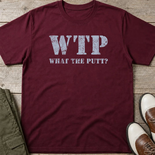 What The Putt T-Shirt in Maroon lying on a plain floor. T-shirt is a unisex cut and 100 per cent cotton.