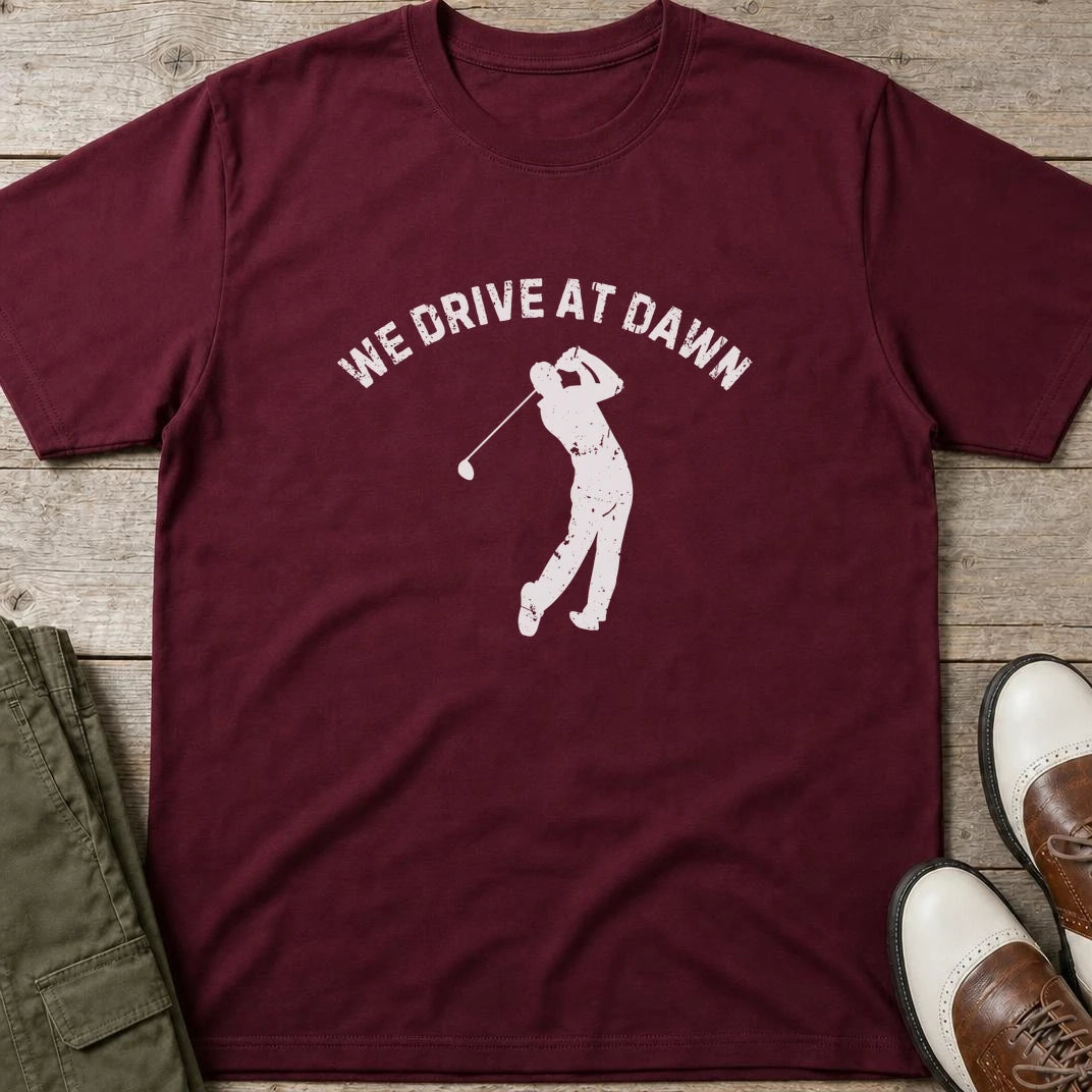 We Drive T-Shirt in Maroon lying on a plain floor. T-shirt is a unisex cut and 100 per cent cotton.