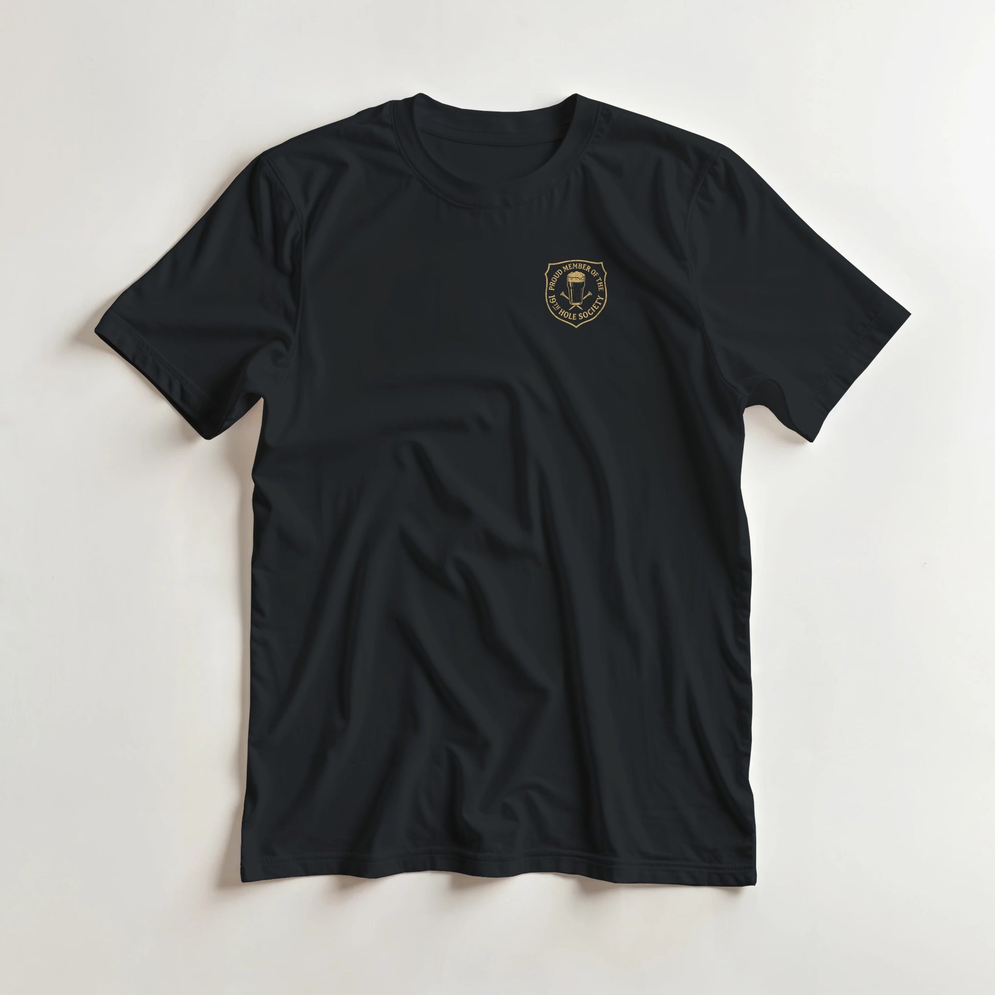 19th Hole T-Shirt in Black S lying on a plain floor. T-shirt is a unisex cut and 100 per cent cotton.