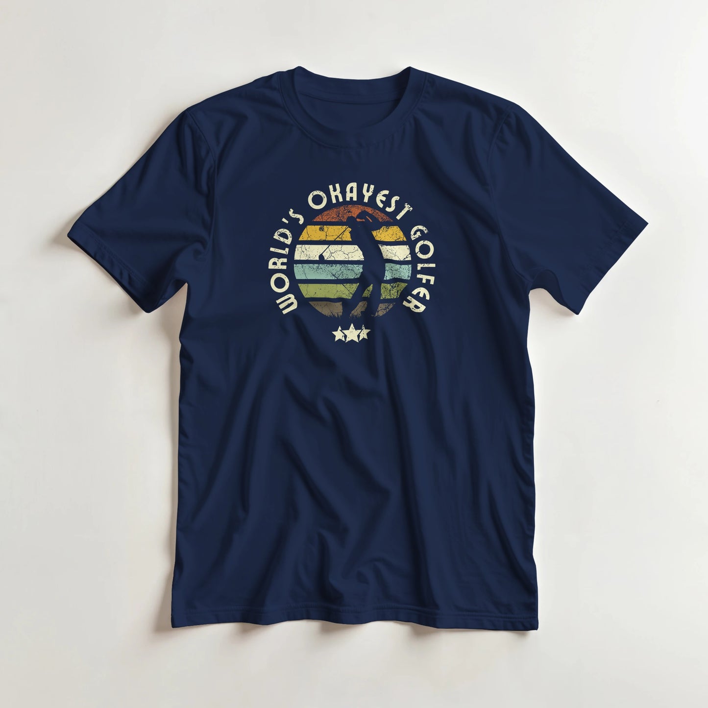 Okayest Golfer T-Shirt in Navy lying on a plain floor. T-shirt is a unisex cut and 100 per cent cotton.