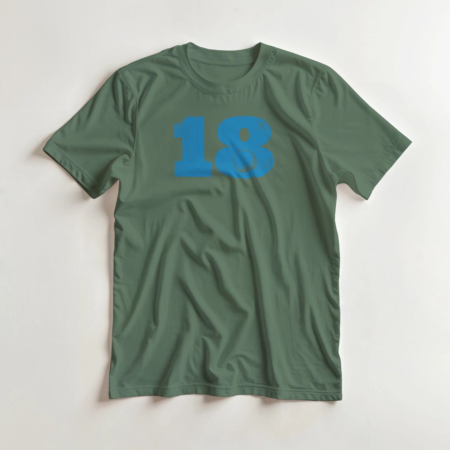 18 Golf T-Shirt in Military Green 3XL lying on a plain floor. T-shirt is a unisex cut and 100 per cent cotton.