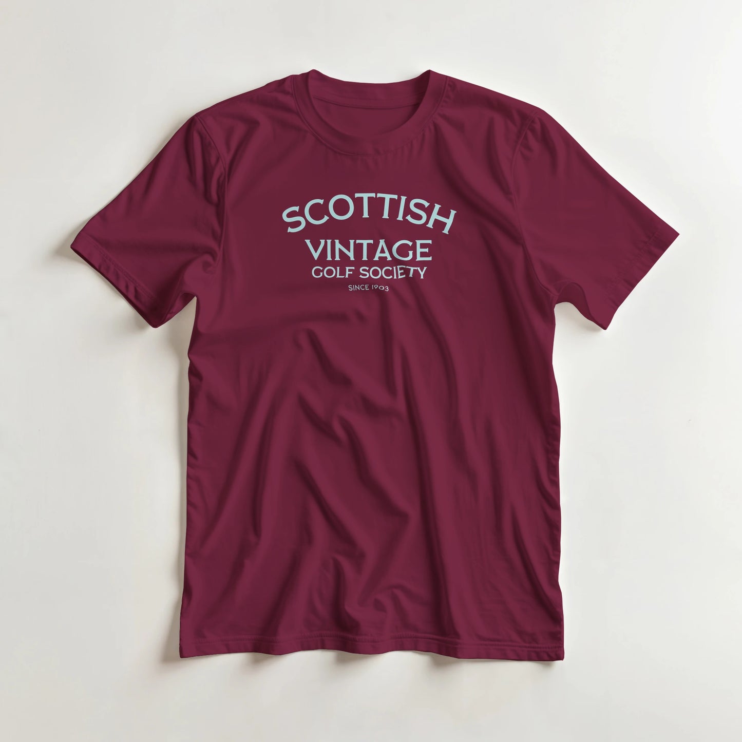 Scottish 1903 T-Shirt in Maroon lying on a plain floor. T-shirt is a unisex cut and 100 per cent cotton.