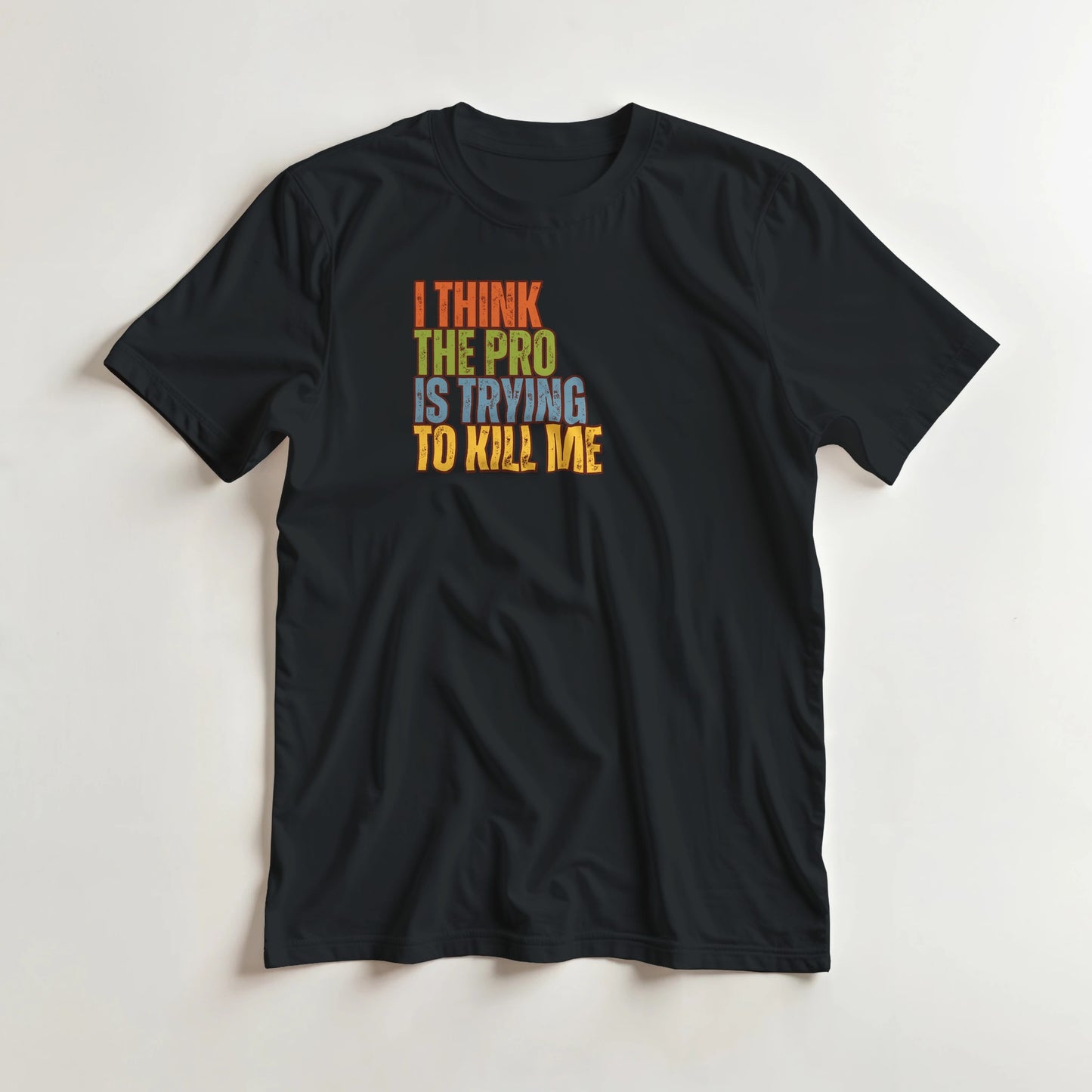 The Pro T-Shirt in Black lying on a plain floor. T-shirt is a unisex cut and 100 per cent cotton.