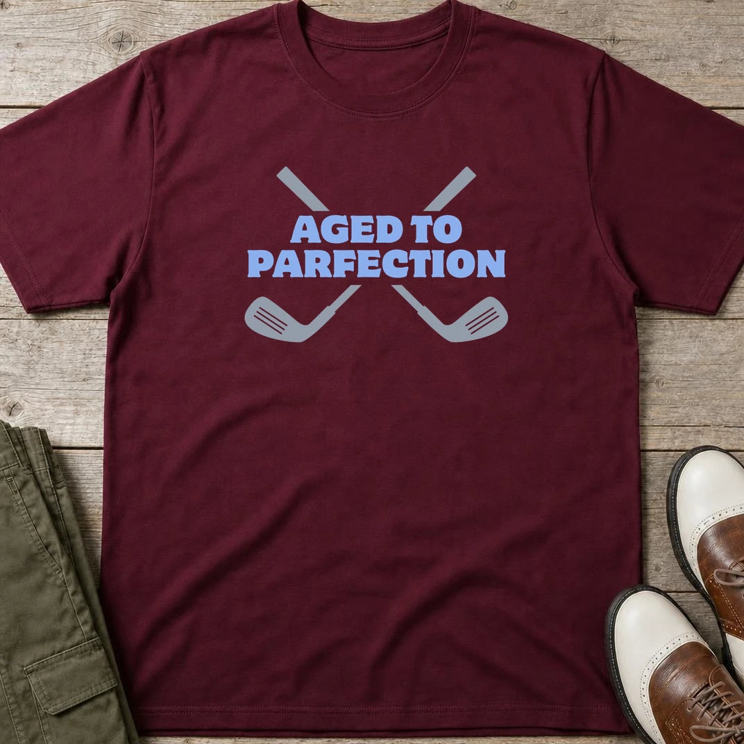 Parfection T-Shirt in Maroon lying on a plain floor. T-shirt is a unisex cut and 100 per cent cotton.