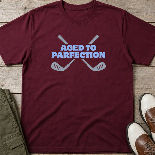 Parfection T-Shirt in Maroon lying on a plain floor. T-shirt is a unisex cut and 100 per cent cotton.