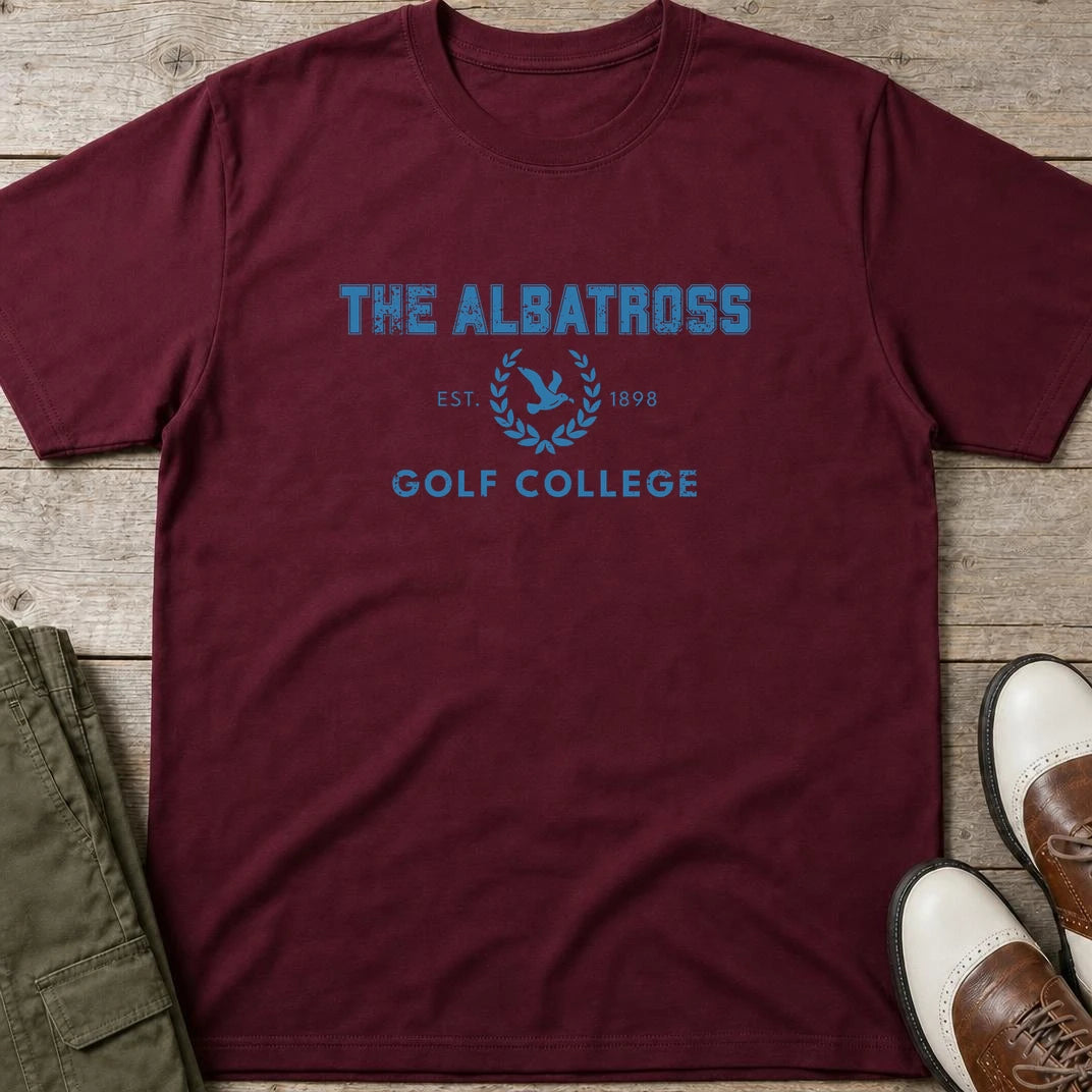 Albatross College T-Shirt in Maroon lying on a plain floor. T-shirt is a unisex cut and 100 per cent cotton.
