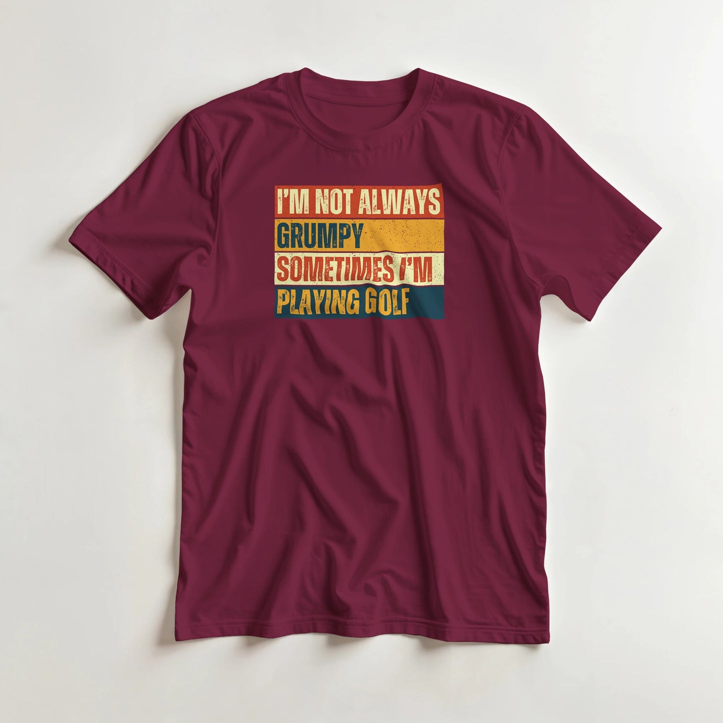 Grumpy Vintage T-Shirt in Maroon lying on a plain floor. T-shirt is a unisex cut and 100 per cent cotton.