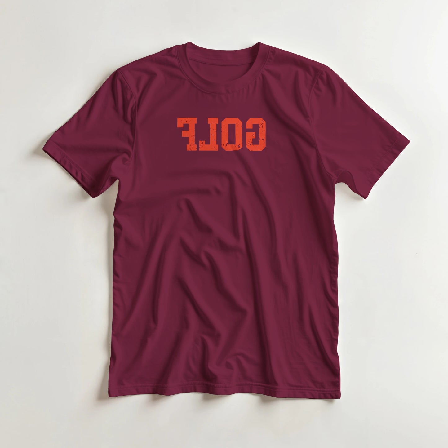 Golf Reverse T-Shirt in Maroon S lying on a plain floor. T-shirt is a unisex cut and 100 per cent cotton.