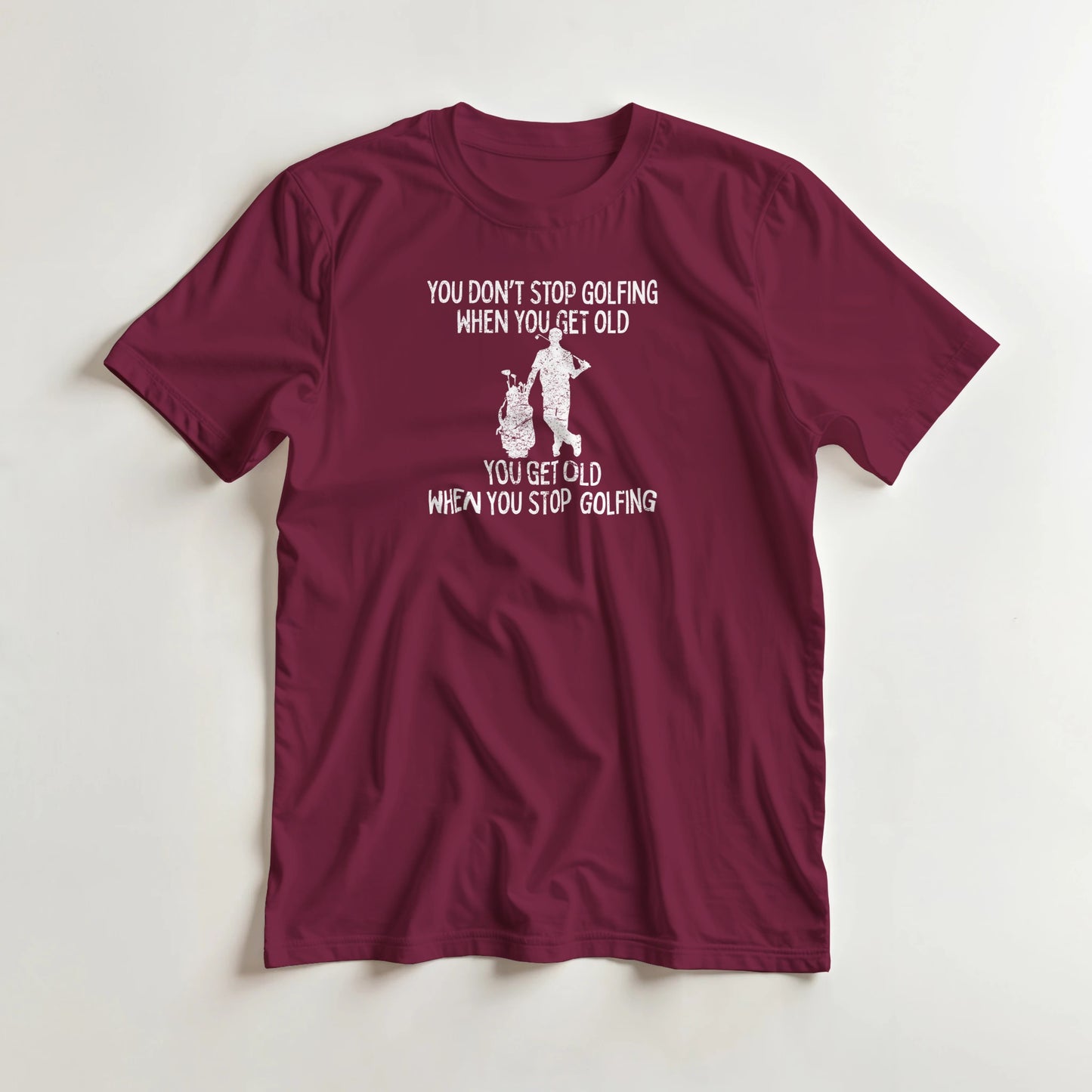 Get Old T-Shirt in Maroon lying on a plain floor. T-shirt is a unisex cut and 100 per cent cotton.