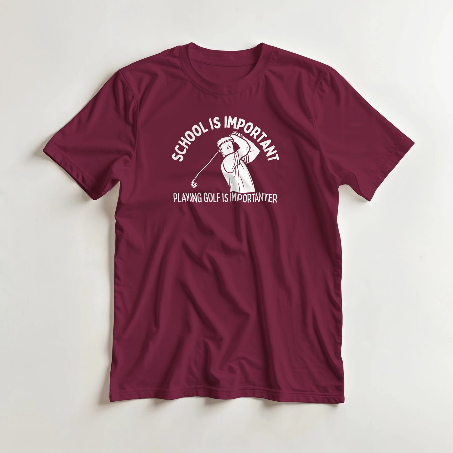 Golf Is Importanter T-Shirt in Maroon M lying on a plain floor. T-shirt is a unisex cut and 100 per cent cotton.