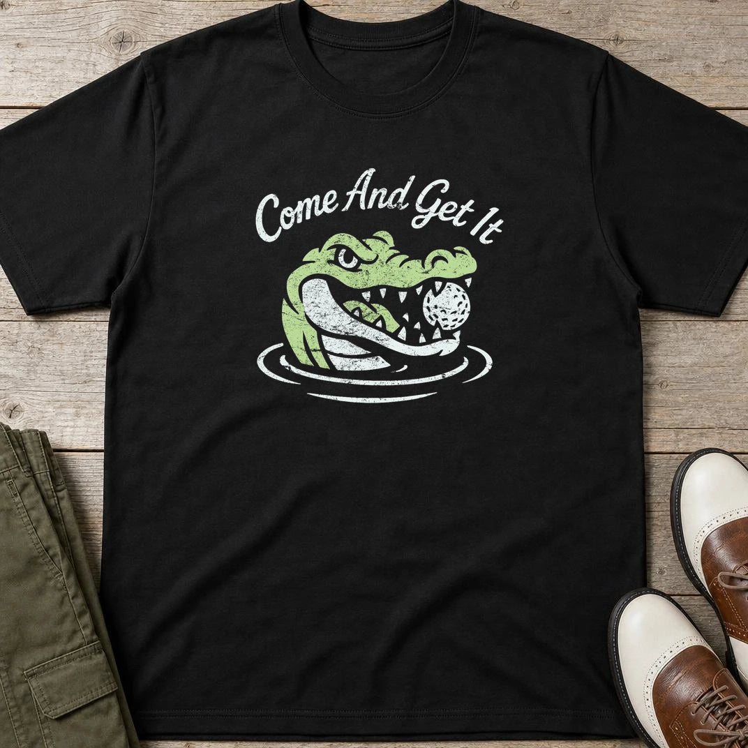 Come And Get It T-Shirt in Black lying on a plain floor. T-shirt is a unisex cut and 100 per cent cotton.