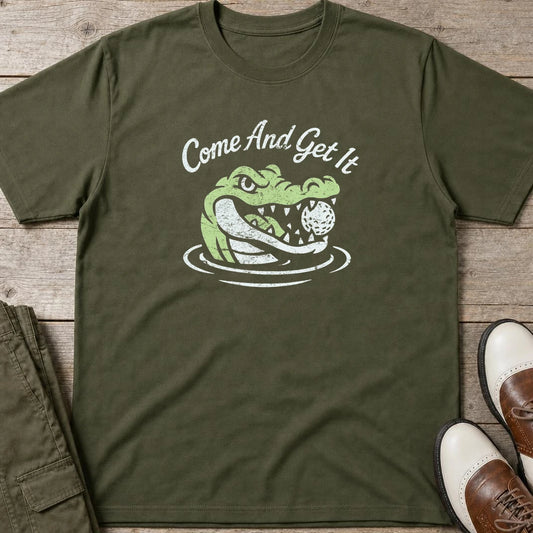 Come And Get It T-Shirt in Military Green lying on a plain floor. T-shirt is a unisex cut and 100 per cent cotton.