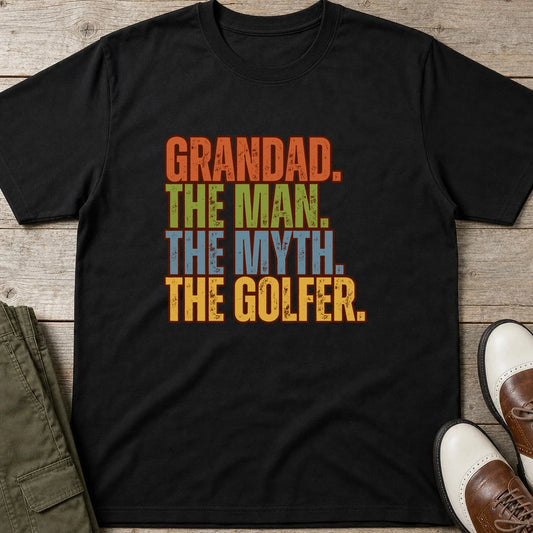 Grandad Golfer T-Shirt in Black lying on a plain floor. T-shirt is a unisex cut and 100 per cent cotton.