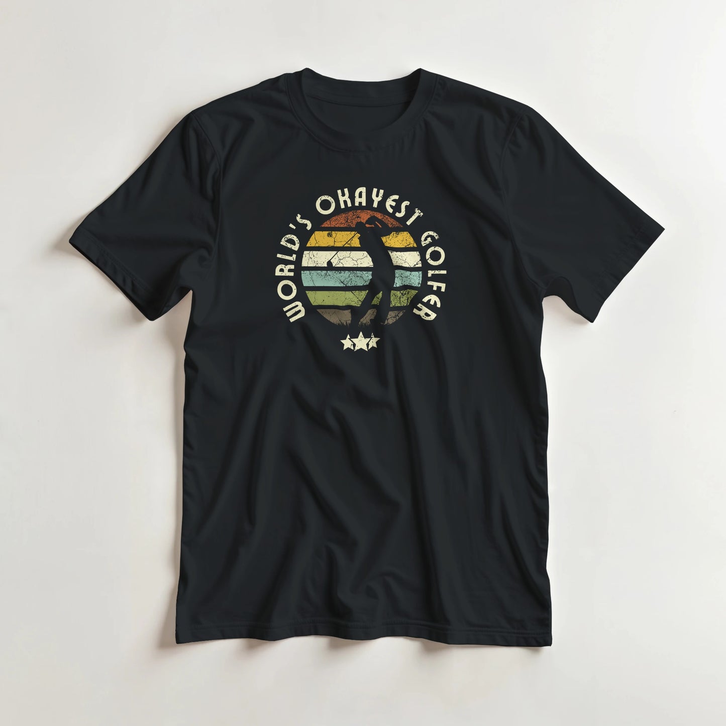 Okayest Golfer T-Shirt in Black lying on a plain floor. T-shirt is a unisex cut and 100 per cent cotton.