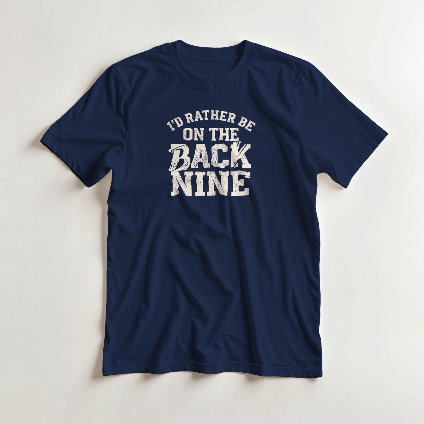 I'd Rather Be T-Shirt in Navy lying on a plain floor. T-shirt is a unisex cut and 100 per cent cotton.