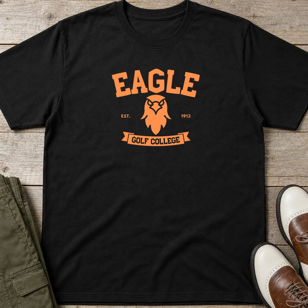 Eagle College T-Shirt in Black lying on a plain floor. T-shirt is a unisex cut and 100 per cent cotton.