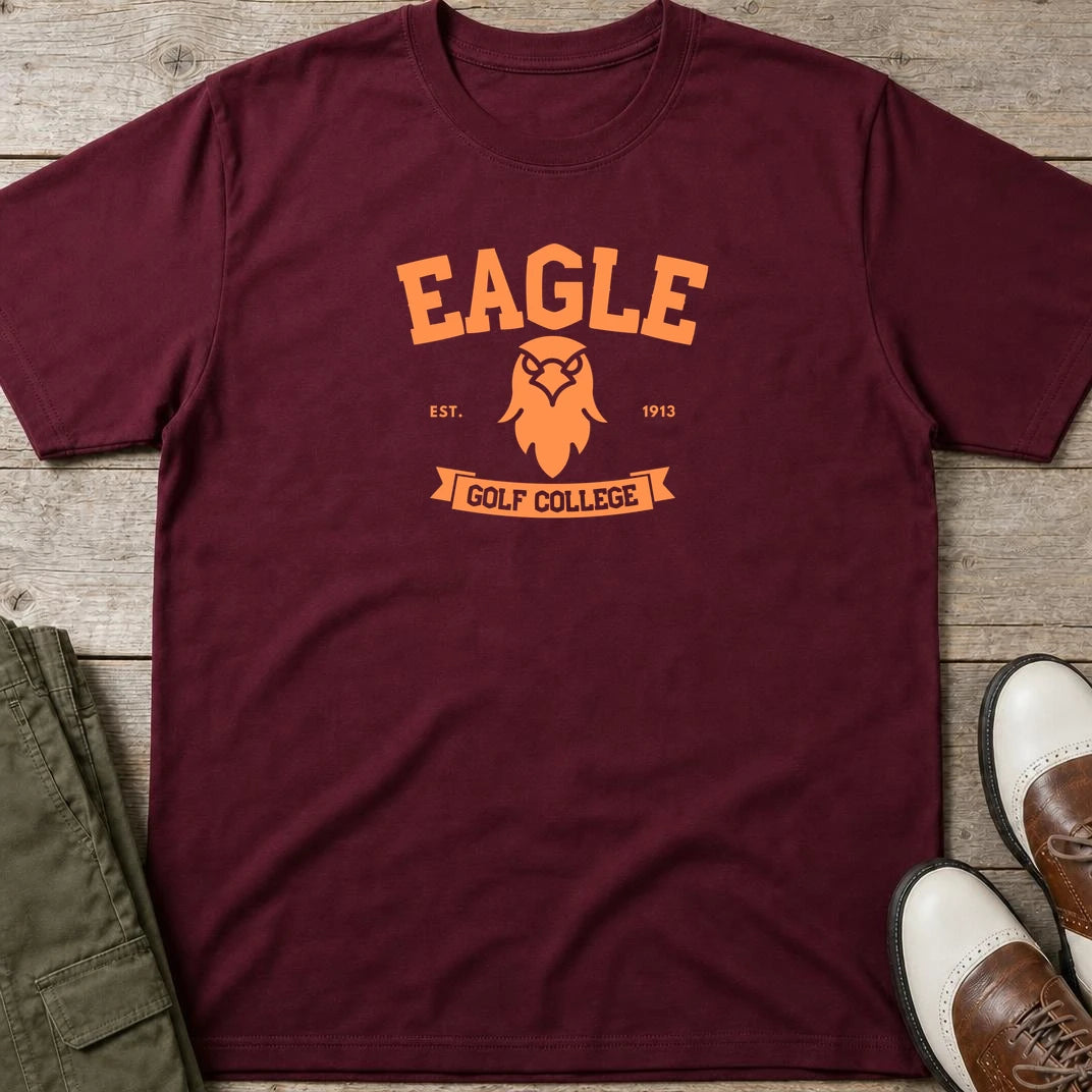 Eagle College T-Shirt in Maroon lying on a plain floor. T-shirt is a unisex cut and 100 per cent cotton.