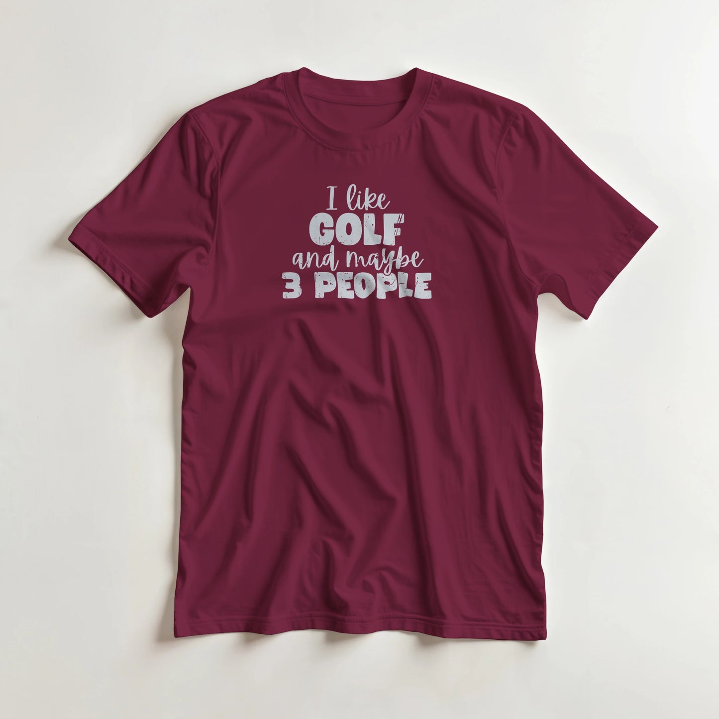 I Like Golf T-Shirt in Maroon S lying on a plain floor. T-shirt is a unisex cut and 100 per cent cotton.