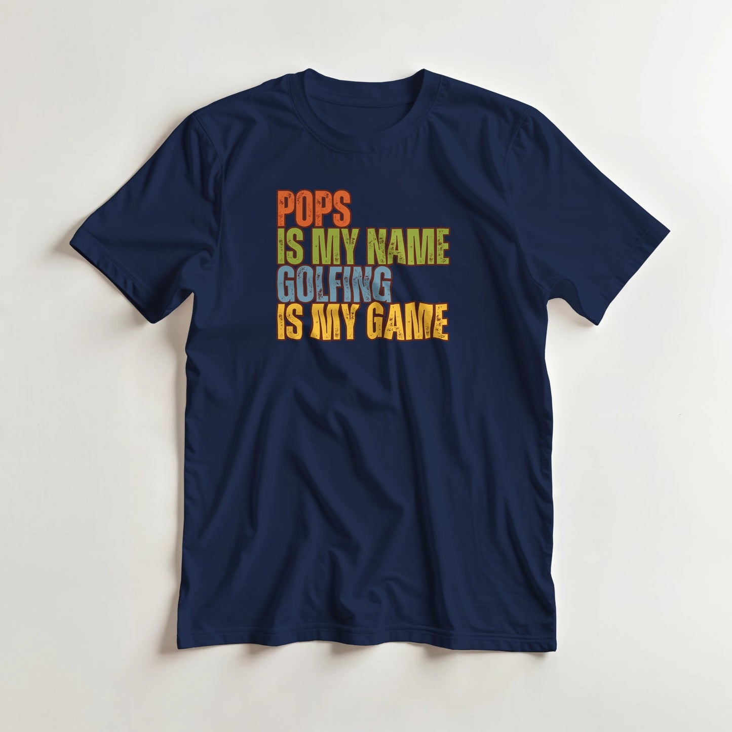Pops My Name T-Shirt in Navy lying on a plain floor. T-shirt is a unisex cut and 100 per cent cotton.