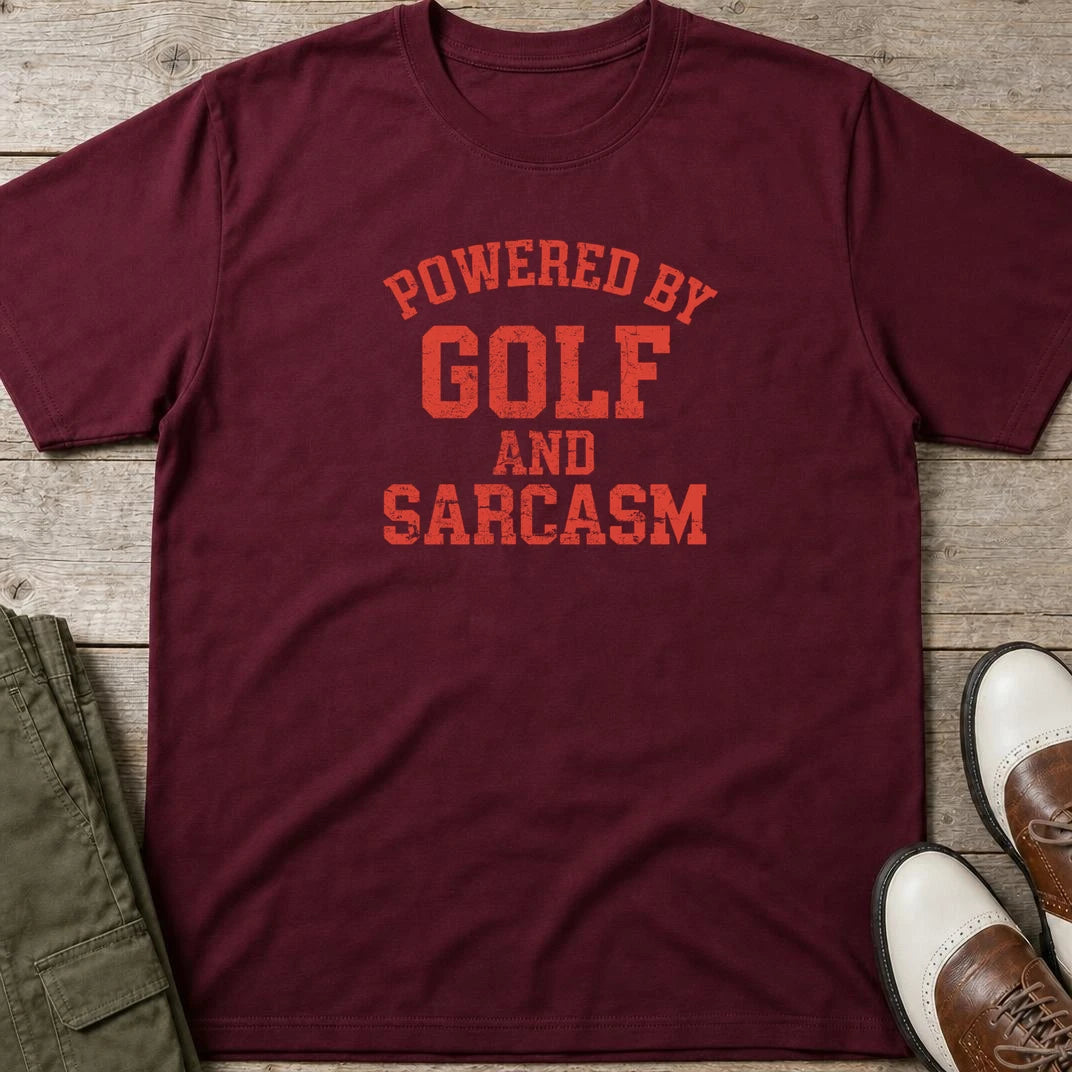Powered By T-Shirt in Maroon lying on a plain floor. T-shirt is a unisex cut and 100 per cent cotton.