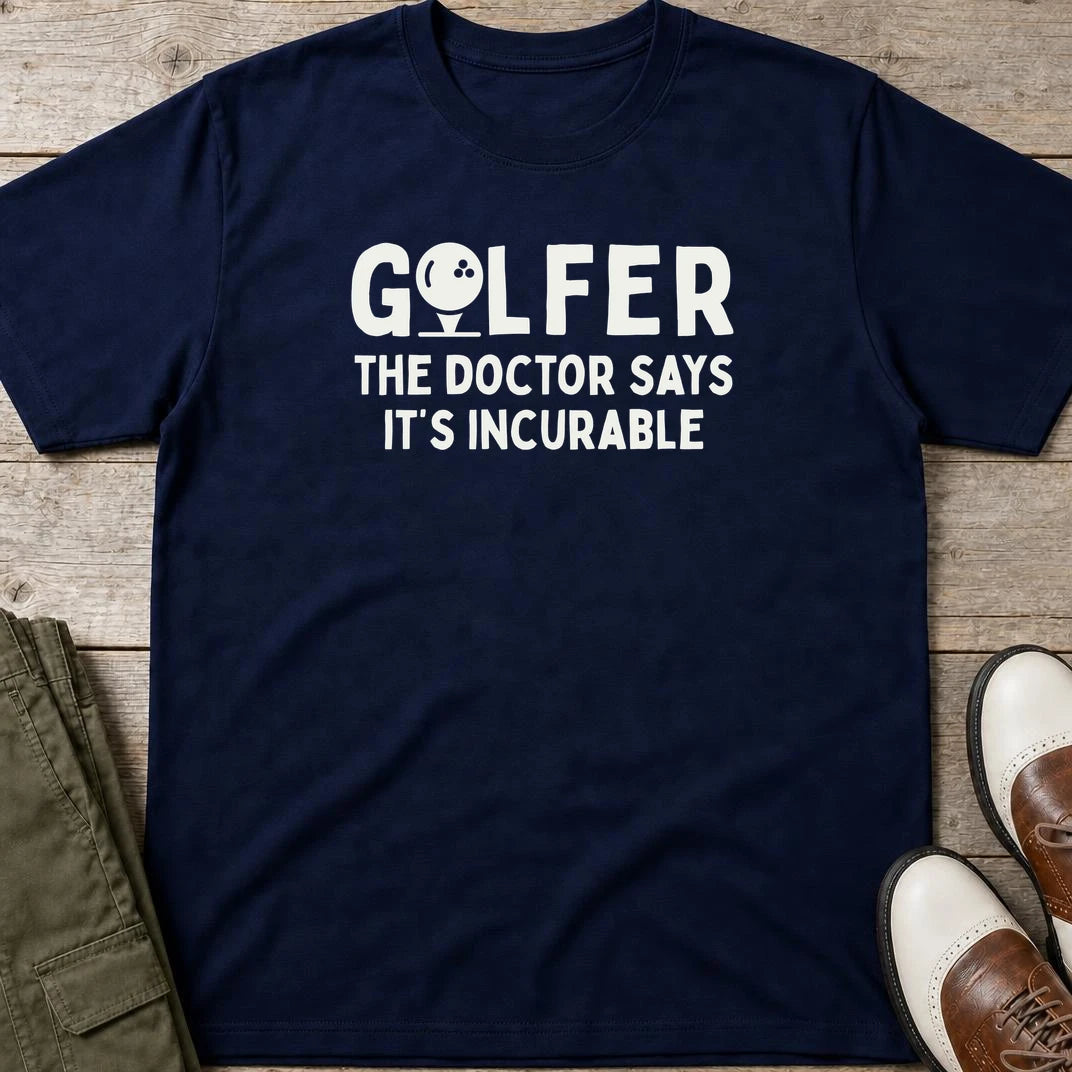 Golfer Incurable T-Shirt in Navy lying on a plain floor. T-shirt is a unisex cut and 100 per cent cotton.