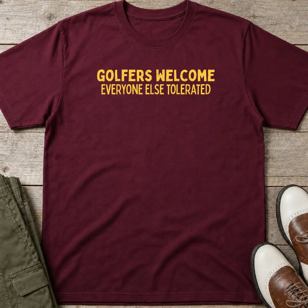 Golfers Welcome T-Shirt in Maroon lying on a plain floor. T-shirt is a unisex cut and 100 per cent cotton.