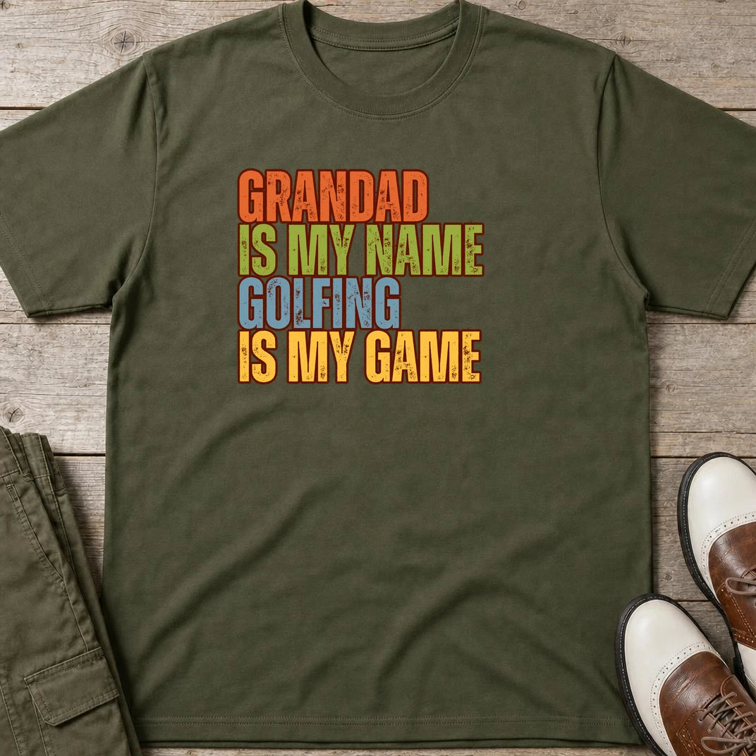 Grandad Golfing T-Shirt in Military Green lying on a plain floor. T-shirt is a unisex cut and 100 per cent cotton.