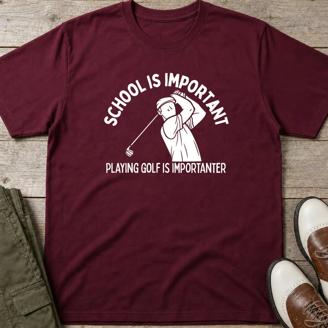 Golf Is Importanter T-Shirt in Maroon lying on a plain floor. T-shirt is a unisex cut and 100 per cent cotton.