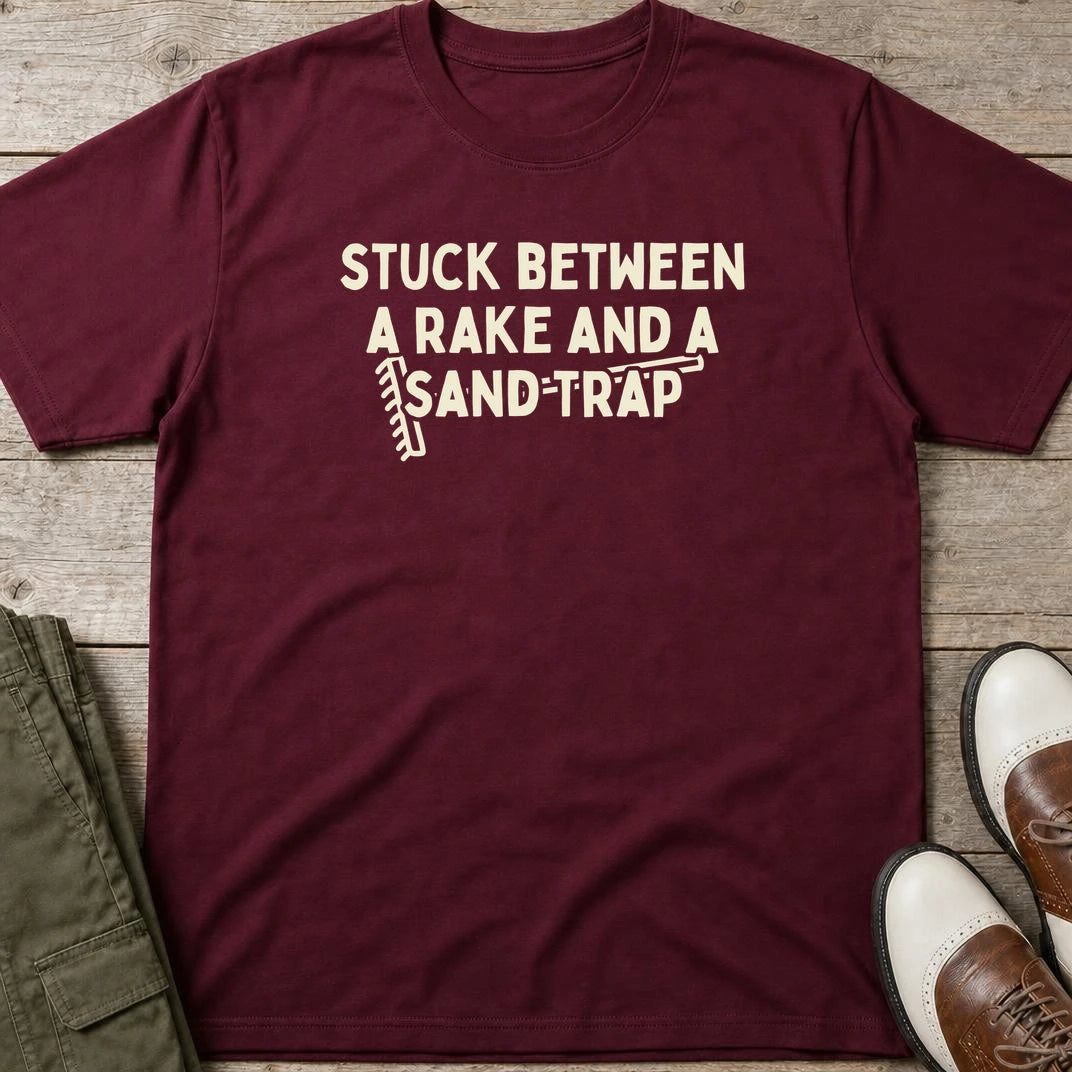Rake Sand Trap T-Shirt in Maroon lying on a plain floor. T-shirt is a unisex cut and 100 per cent cotton.
