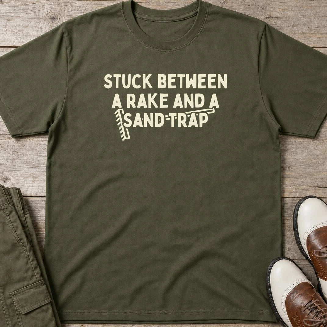 Rake Sand Trap T-Shirt in Military Green lying on a plain floor. T-shirt is a unisex cut and 100 per cent cotton.