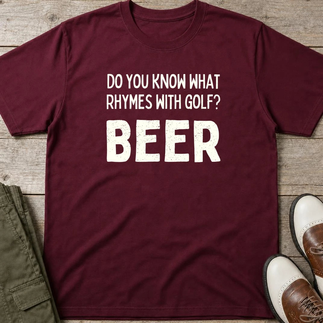 Rhymes With Golf T-Shirt in Maroon lying on a plain floor. T-shirt is a unisex cut and 100 per cent cotton.