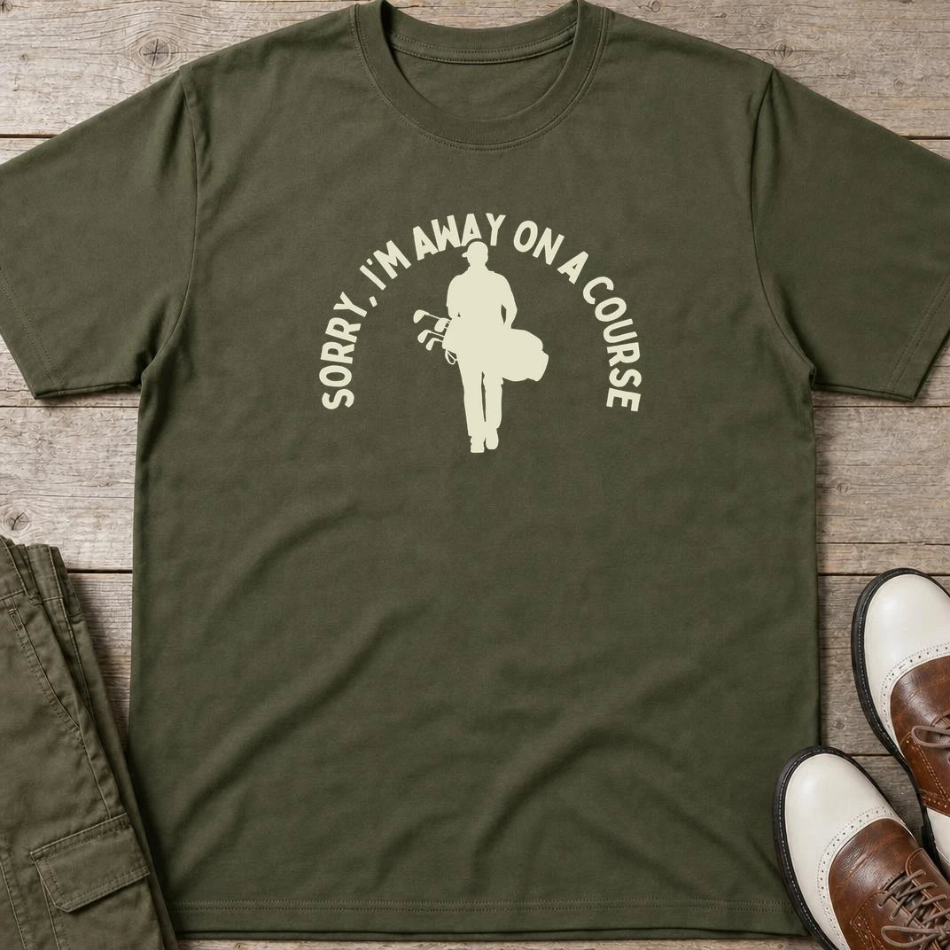 On A Course T-Shirt in Military Green lying on a plain floor. T-shirt is a unisex cut and 100 per cent cotton.