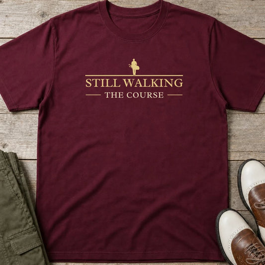 Still Walking T-Shirt in Maroon lying on a plain floor. T-shirt is a unisex cut and 100 per cent cotton.