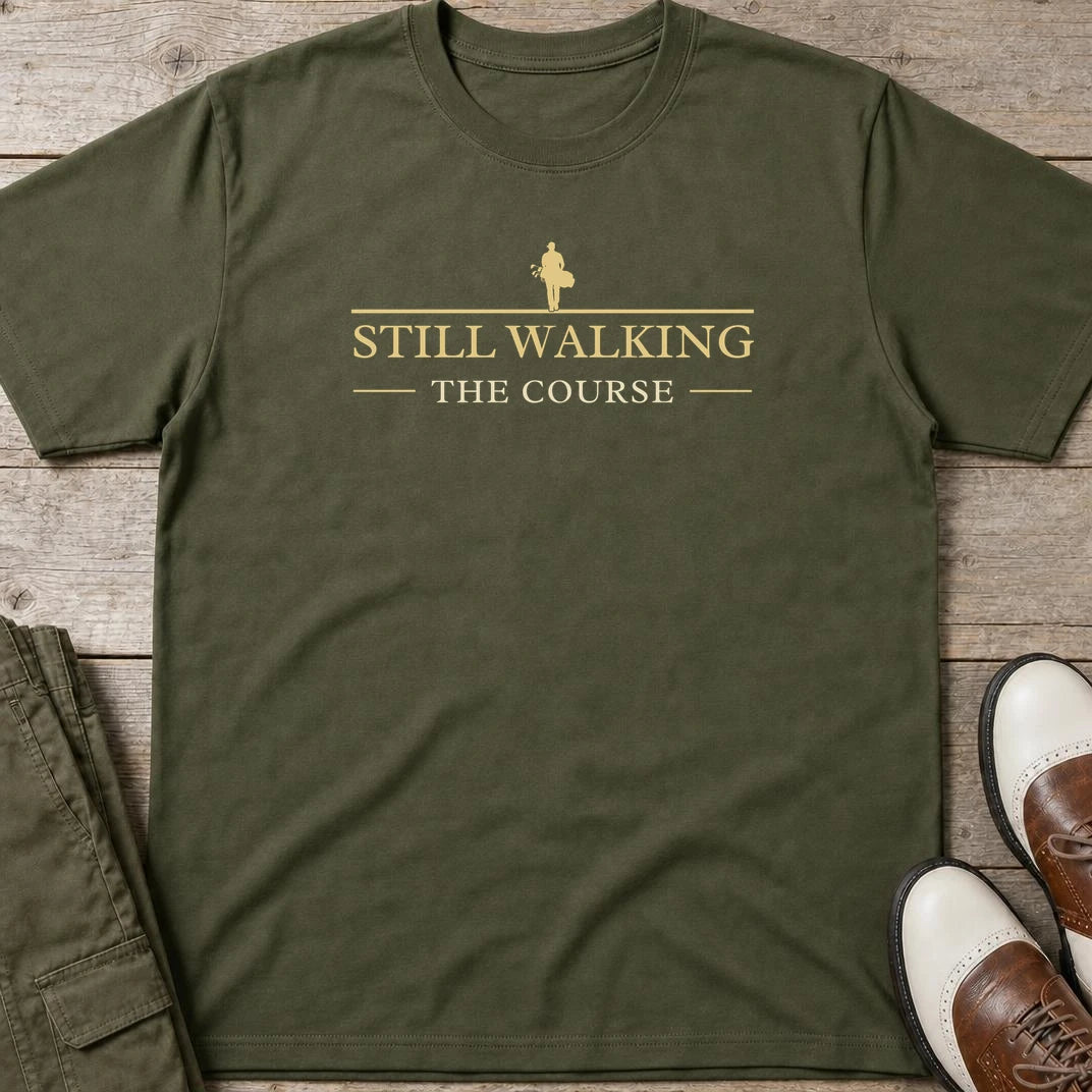 Still Walking T-Shirt in Military Green lying on a plain floor. T-shirt is a unisex cut and 100 per cent cotton.