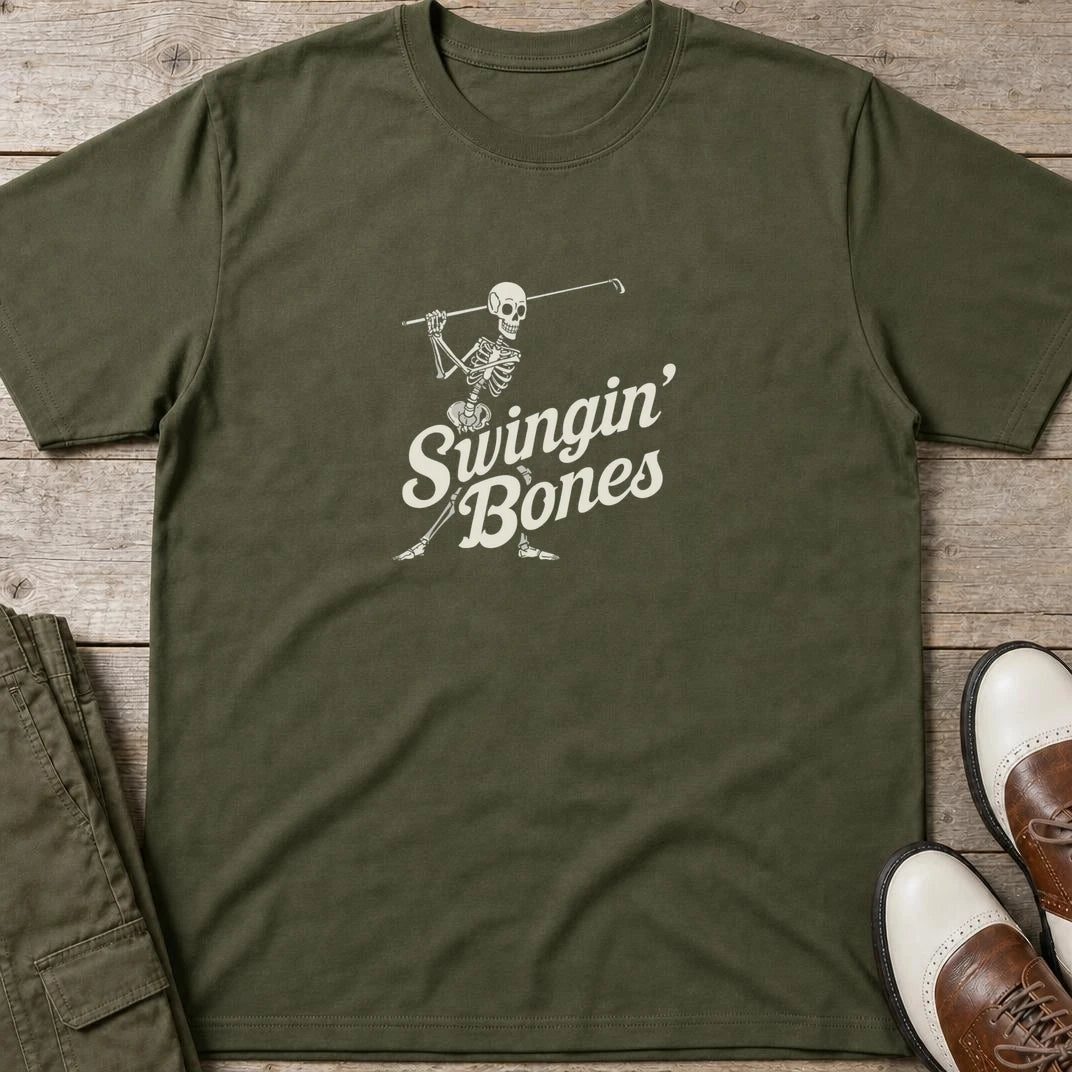 Swingin' Bones T-Shirt in Military Green lying on a plain floor. T-shirt is a unisex cut and 100 per cent cotton.