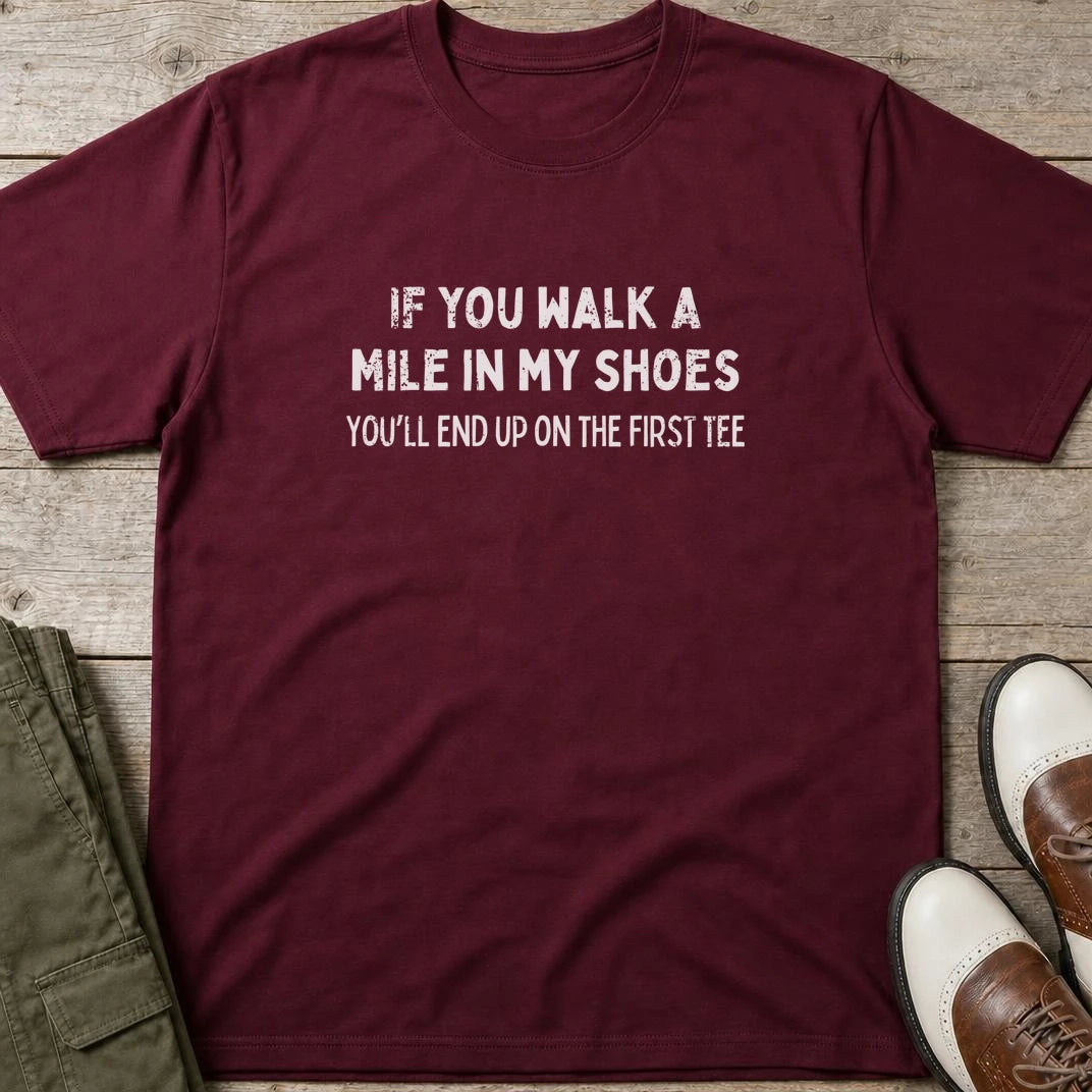 Walk A Mile T-Shirt in Maroon lying on a plain floor. T-shirt is a unisex cut and 100 per cent cotton.