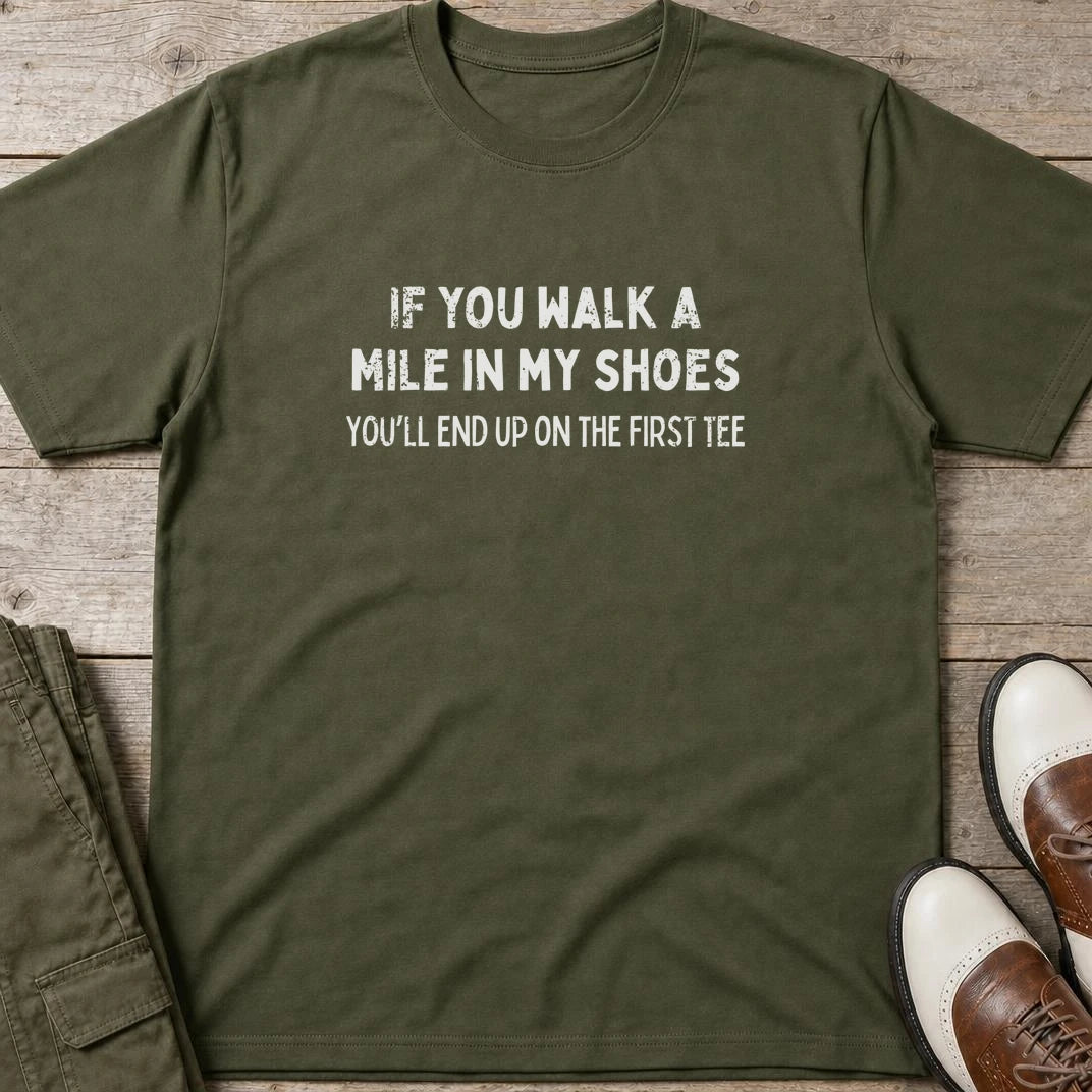Walk A Mile T-Shirt in Military Green lying on a plain floor. T-shirt is a unisex cut and 100 per cent cotton.