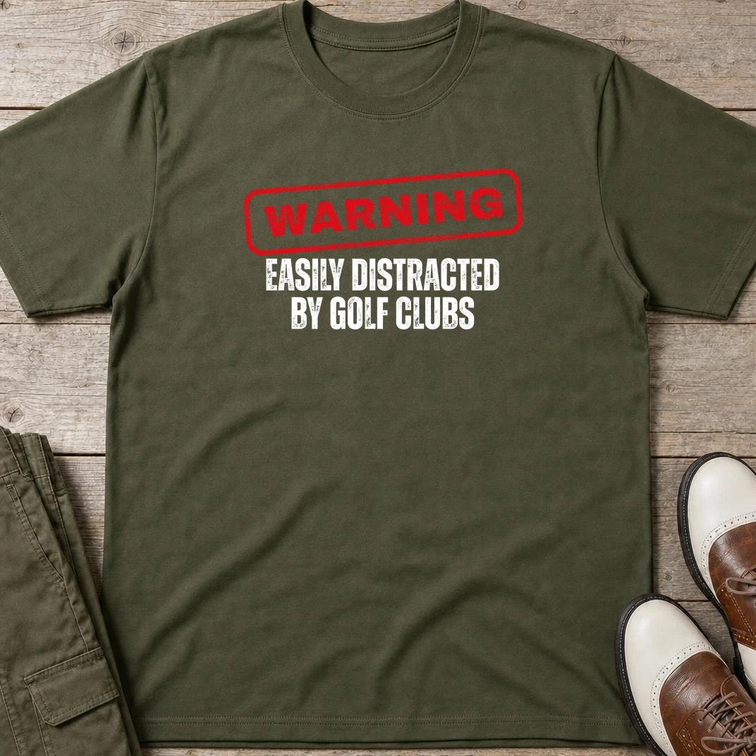Warning T-Shirt in Military Green lying on a plain floor. T-shirt is a unisex cut and 100 per cent cotton.